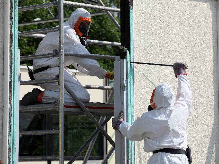 Removing asbestos from building in hazard suits