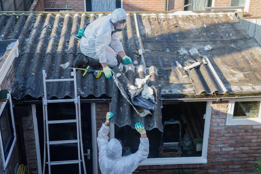 People in hazard suits removing asbestos roofing