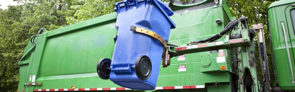 Green recycling lorry emptying recycle bin